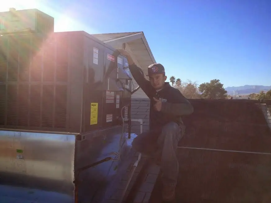 HVAC technician performing Boiler Repair on a rooftop unit in Somersworth